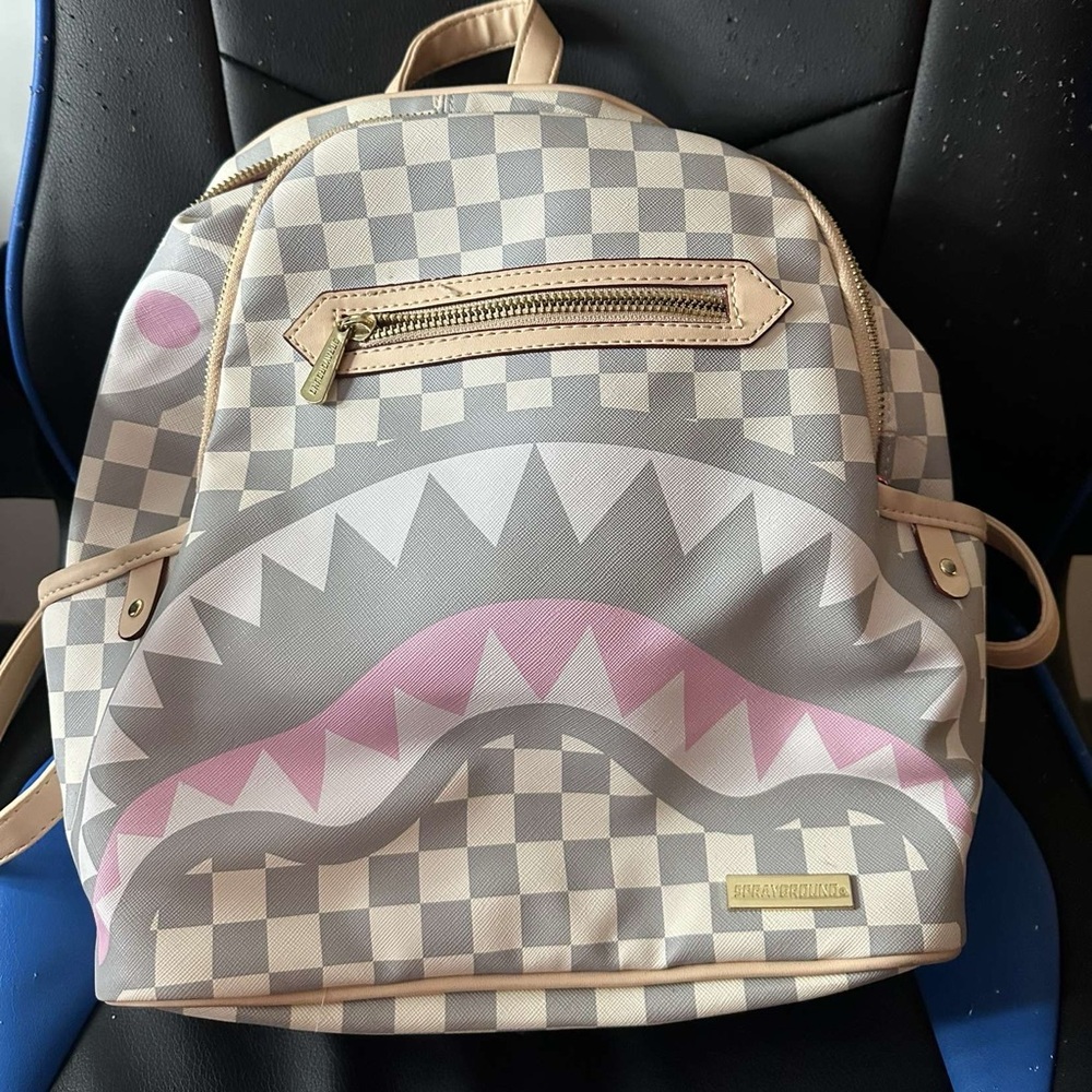 sprayground pink, white, and grey backpack